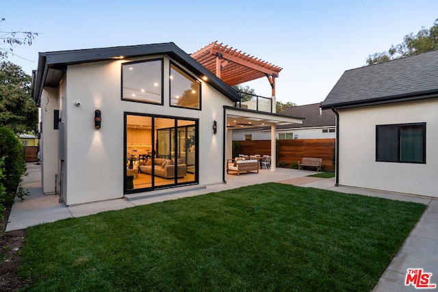 rear view of property featuring a patio area, outdoor lounge area, a lawn, and a pergola