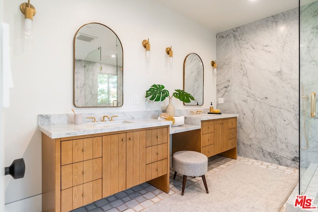 bathroom featuring a tile shower and vanity