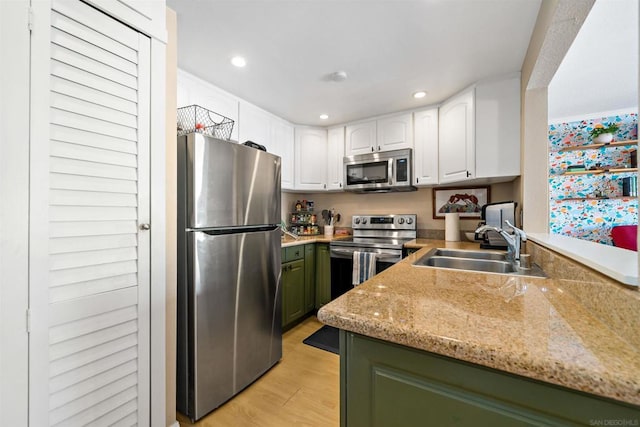 kitchen with sink, white cabinetry, green cabinetry, light hardwood / wood-style floors, and stainless steel appliances