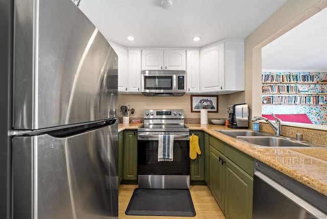 kitchen featuring sink, stainless steel appliances, white cabinetry, and green cabinetry