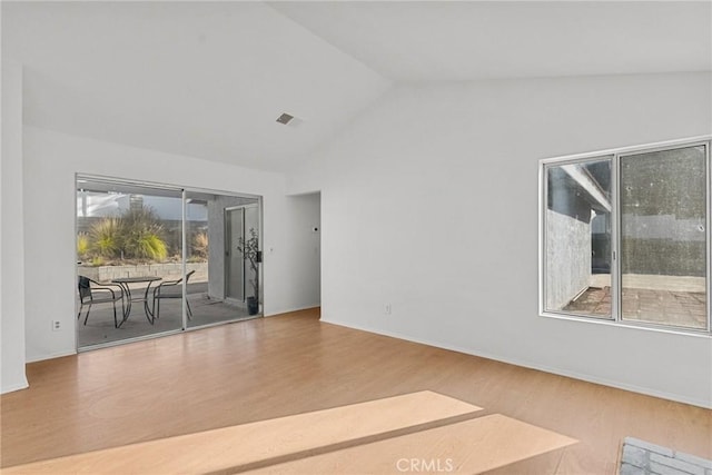 unfurnished room featuring wood-type flooring and vaulted ceiling