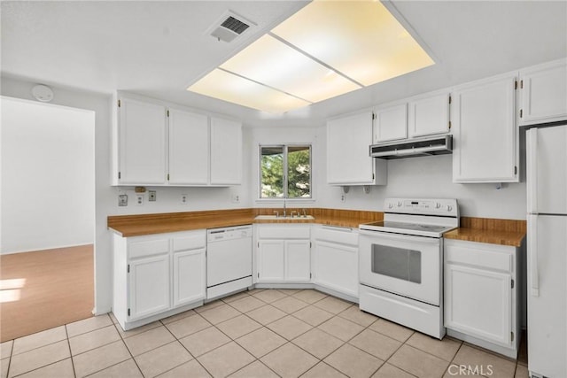 kitchen featuring light tile patterned floors, white appliances, white cabinets, and sink