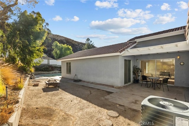 rear view of house with a mountain view, a patio area, and central AC unit