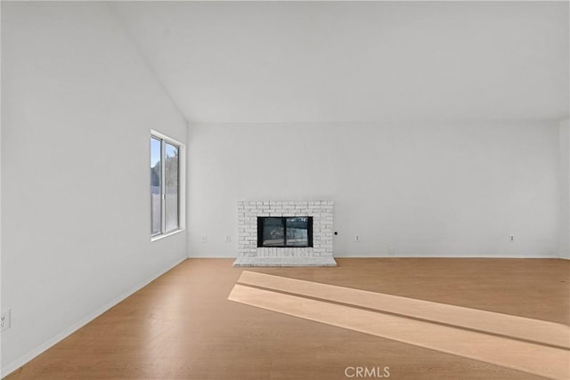 unfurnished living room with high vaulted ceiling, hardwood / wood-style floors, and a fireplace