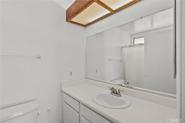 bathroom with toilet, a shower, and vanity