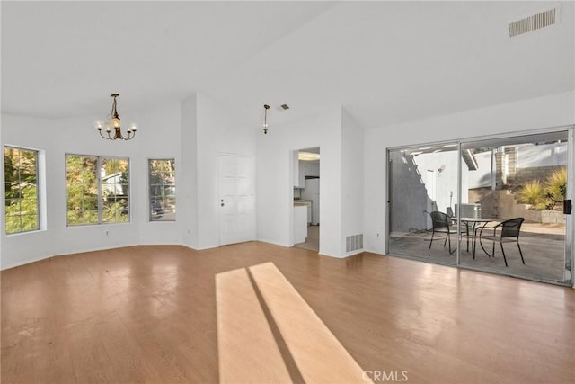 unfurnished living room featuring wood-type flooring and a chandelier