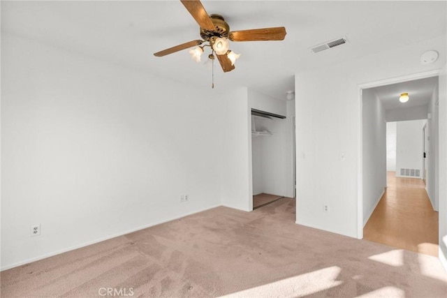 unfurnished bedroom with light colored carpet, a closet, and ceiling fan