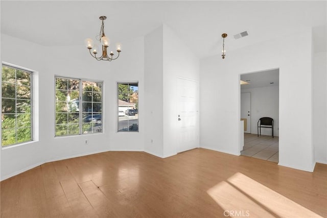 unfurnished room featuring wood-type flooring and a notable chandelier