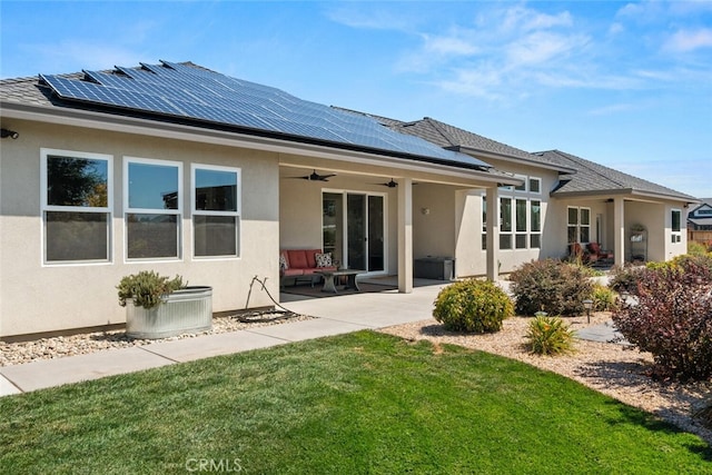 rear view of property with cooling unit, a patio, solar panels, a lawn, and ceiling fan