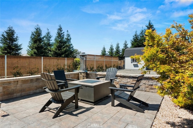 view of patio / terrace with a fire pit and a storage unit