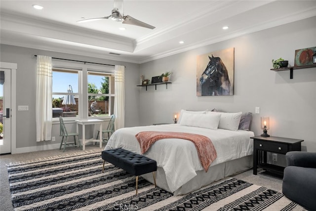 carpeted bedroom featuring a raised ceiling, ceiling fan, and ornamental molding