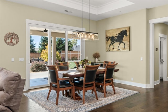 dining area featuring crown molding, dark hardwood / wood-style floors, and a tray ceiling