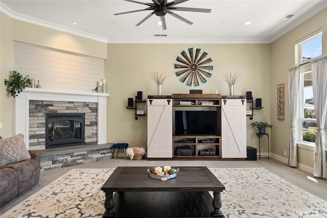 carpeted living room with ceiling fan, crown molding, plenty of natural light, and a fireplace