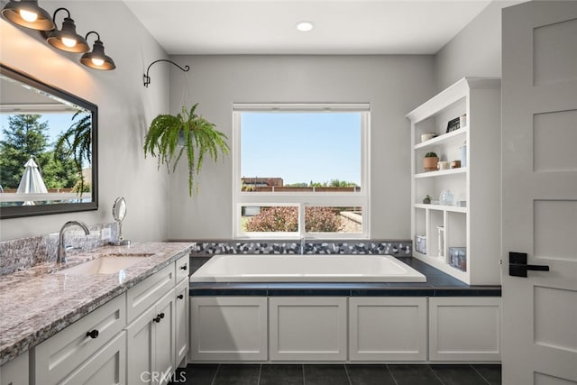 bathroom with vanity, a tub, and tile patterned floors