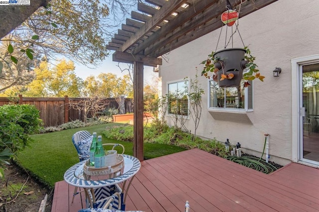 deck featuring a pergola and a lawn