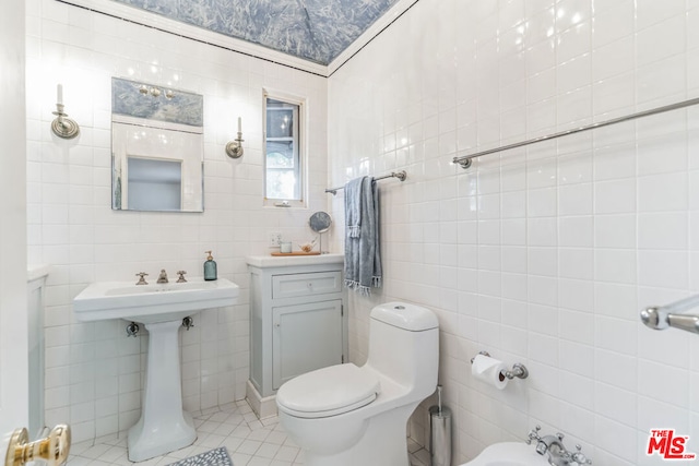 bathroom featuring a bidet, tile patterned flooring, toilet, and tile walls