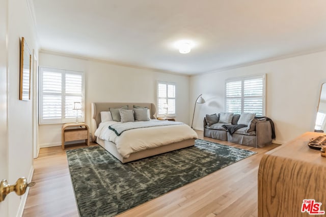 bedroom featuring ornamental molding and light wood-type flooring