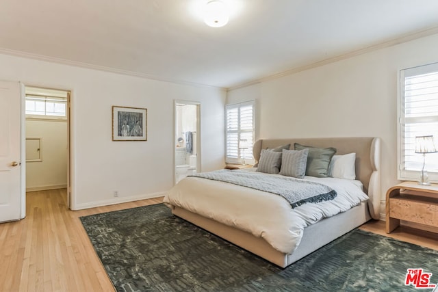 bedroom featuring crown molding, connected bathroom, and hardwood / wood-style flooring