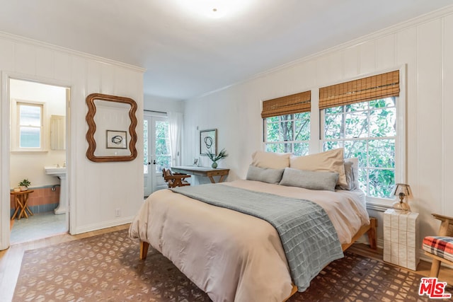 bedroom with hardwood / wood-style flooring, ornamental molding, and ensuite bathroom