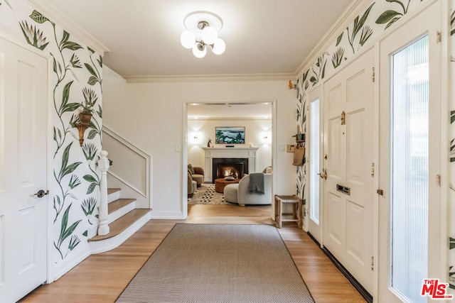 entrance foyer featuring crown molding and light wood-type flooring