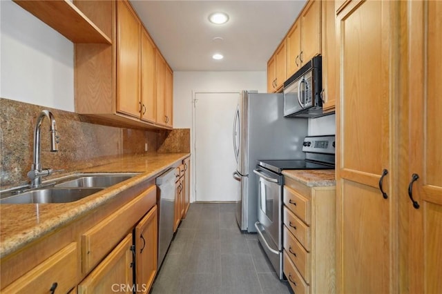 kitchen featuring sink, decorative backsplash, light stone countertops, and appliances with stainless steel finishes