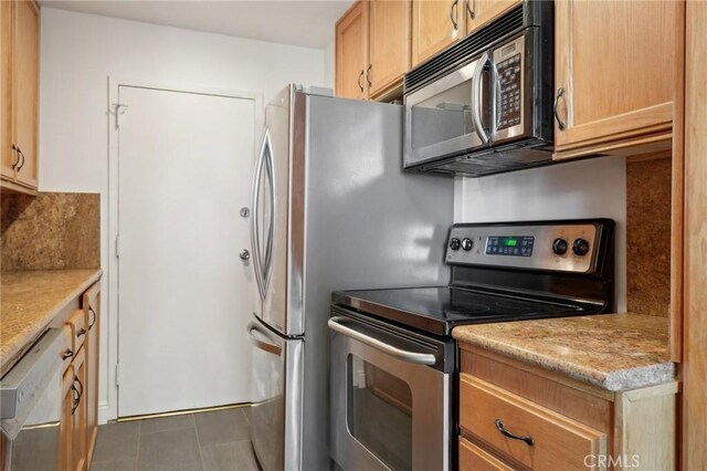 kitchen with tile patterned floors, light brown cabinetry, and stainless steel range with electric cooktop