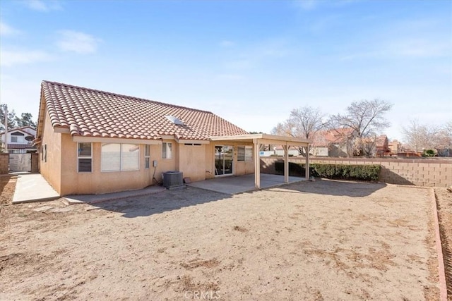 rear view of house featuring cooling unit and a patio