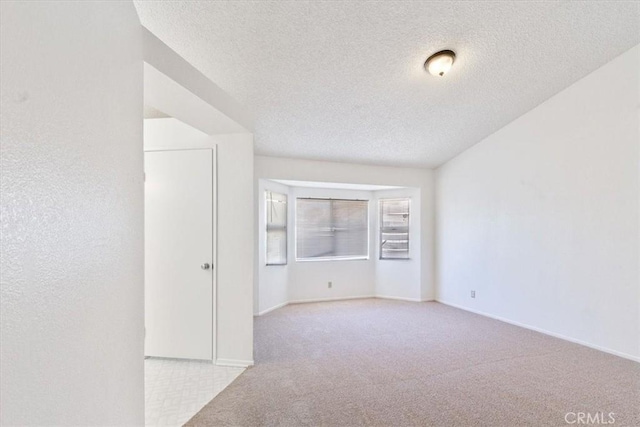 carpeted spare room featuring a textured ceiling