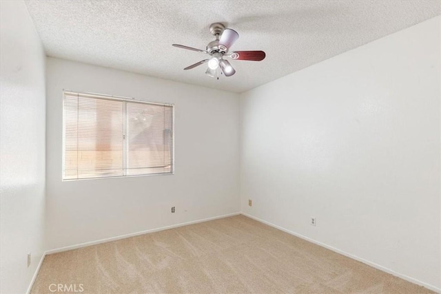 carpeted empty room featuring ceiling fan and a textured ceiling