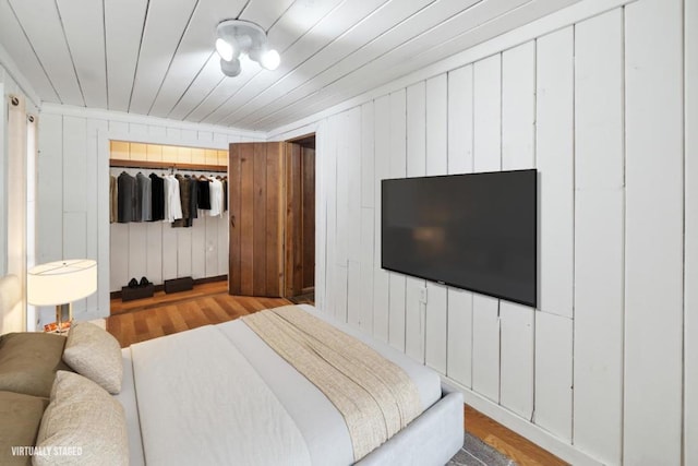 bedroom with wood ceiling, light hardwood / wood-style flooring, and a closet