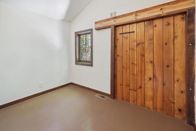 unfurnished bedroom with vaulted ceiling and wood-type flooring