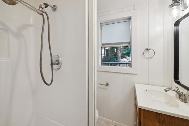 bathroom featuring vanity, toilet, and a shower