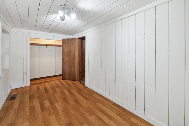 empty room with wood-type flooring and wooden ceiling