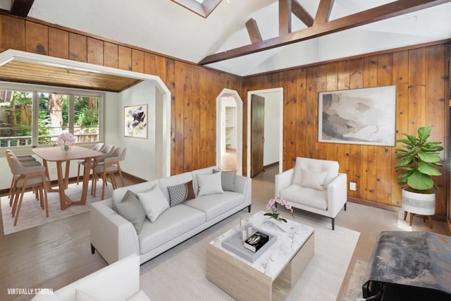 living room with lofted ceiling with skylight, light hardwood / wood-style floors, and wood walls