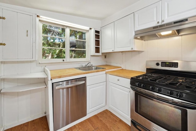 kitchen featuring sink, light hardwood / wood-style flooring, butcher block counters, stainless steel appliances, and white cabinets