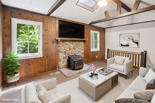 living room with lofted ceiling with beams, a wood stove, and wood walls