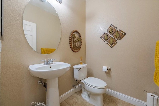 bathroom with sink, toilet, and tile patterned flooring