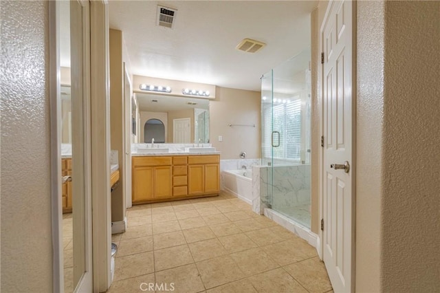 bathroom featuring tile patterned flooring, vanity, and plus walk in shower