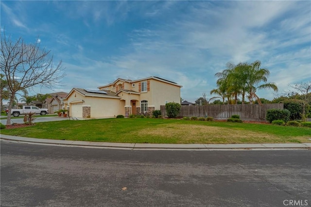 mediterranean / spanish-style home with a garage, a front lawn, and solar panels