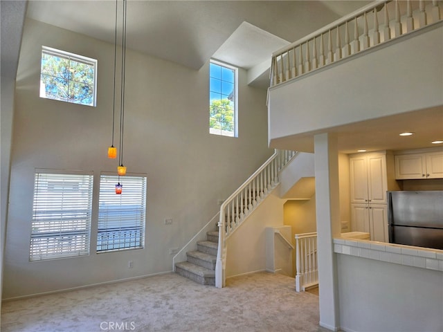 stairs featuring carpet floors and a high ceiling