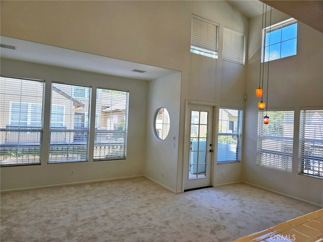 entryway with a high ceiling and carpet