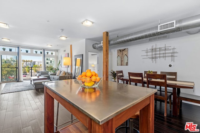 dining room featuring a wall of windows and dark hardwood / wood-style floors