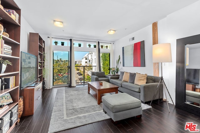 living room featuring a wall of windows and dark hardwood / wood-style floors