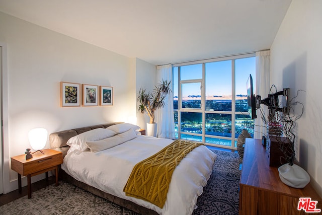 bedroom featuring expansive windows and hardwood / wood-style floors