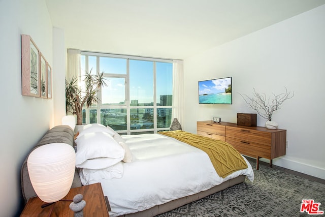 bedroom featuring hardwood / wood-style floors and a wall of windows