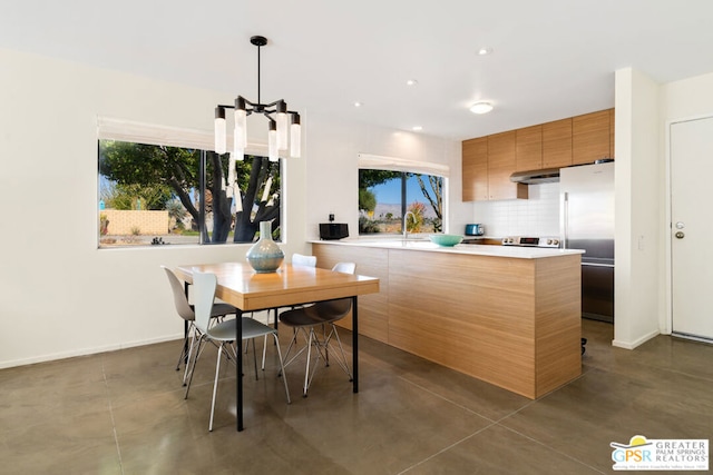 kitchen featuring built in fridge, range, extractor fan, decorative light fixtures, and decorative backsplash