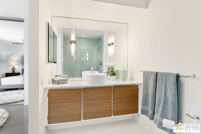 bathroom featuring vanity, a tile shower, and tile patterned flooring