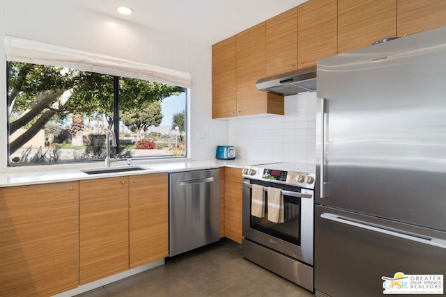 kitchen featuring sink, dark tile patterned flooring, and appliances with stainless steel finishes