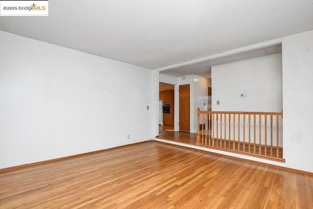 empty room featuring hardwood / wood-style flooring and a textured ceiling