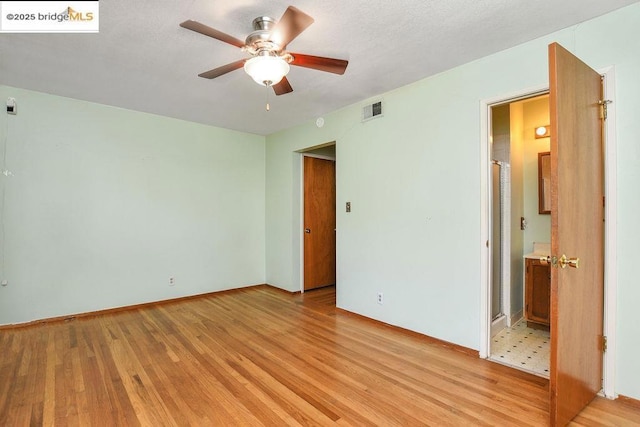 unfurnished bedroom featuring ceiling fan, light hardwood / wood-style flooring, and ensuite bathroom